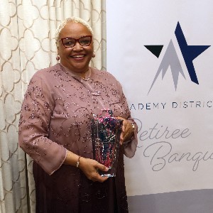 BJ Campbell smiles a for picture with her vase at the 2023 Retiree Banquet